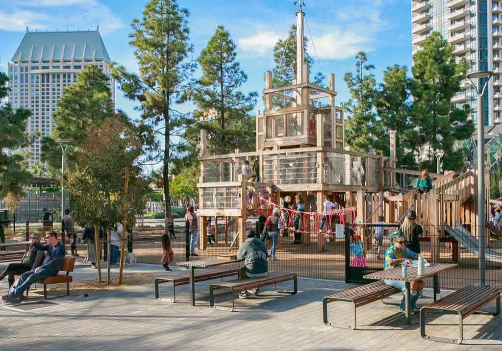 An urban playground made from wood material nestled within a tree-lined setting