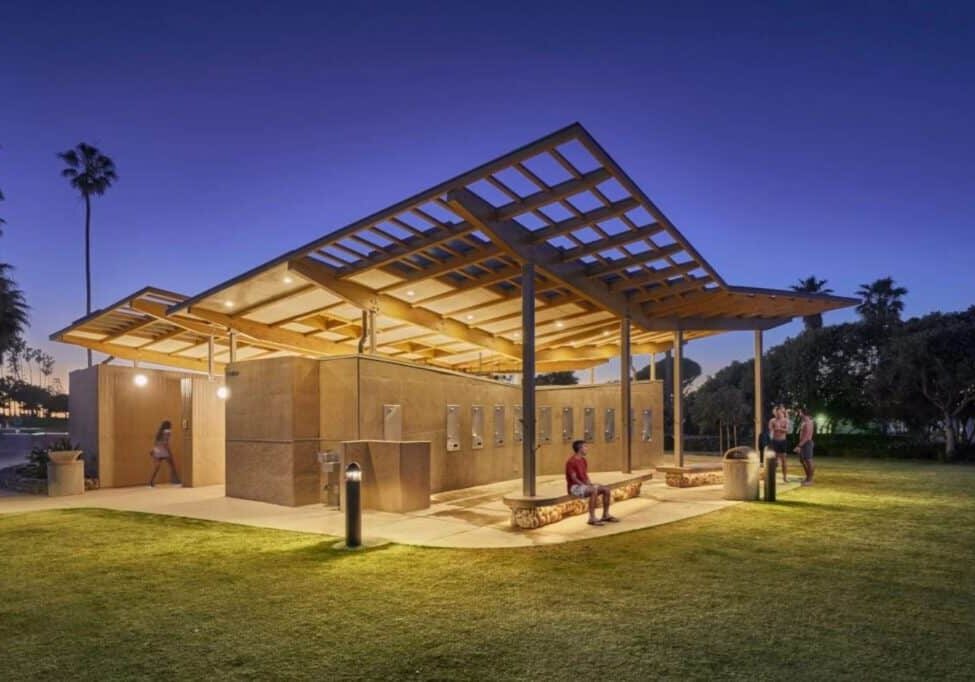 A modern building at dusk that glows with lights from the inside.