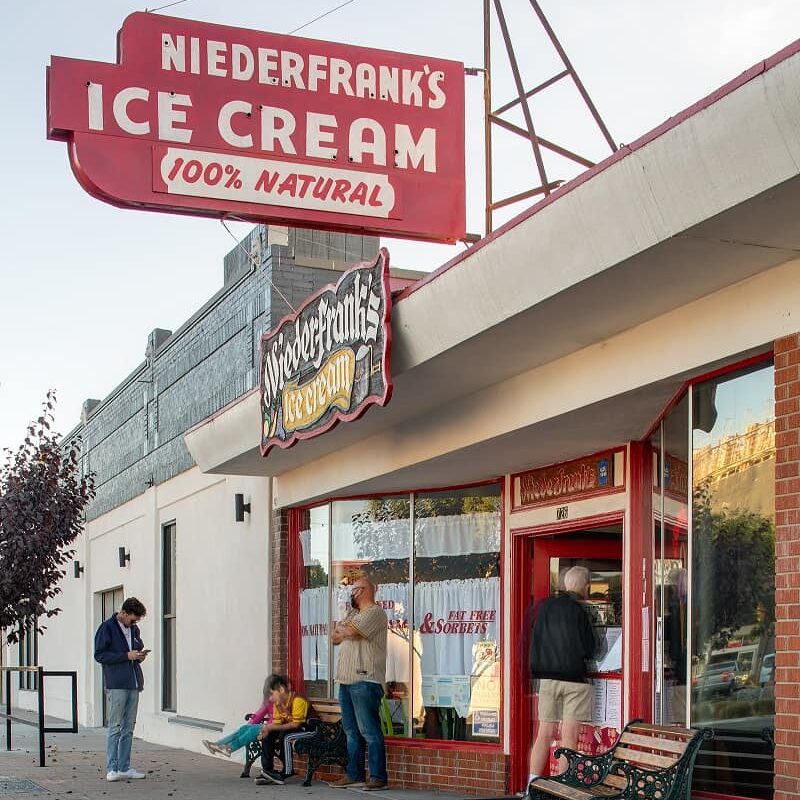 Mid-century ice cream show with large glass windows and the historic Neiderfranks Ice Cream sign hanging over the building.