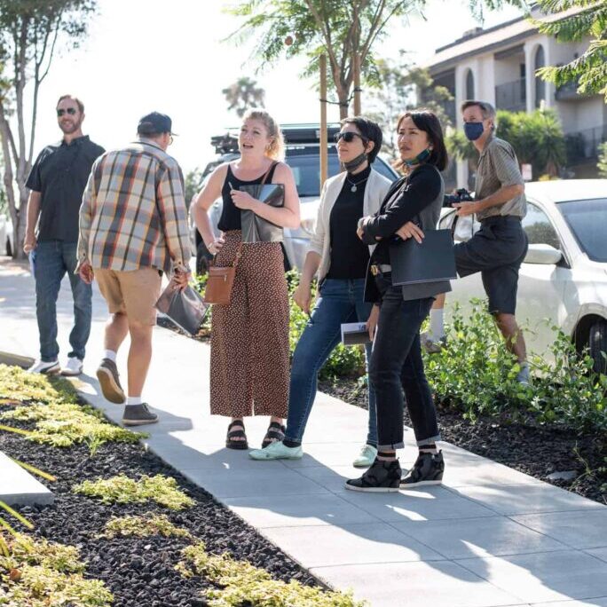 Group of people on the sidewalk in a residential neighborhood.