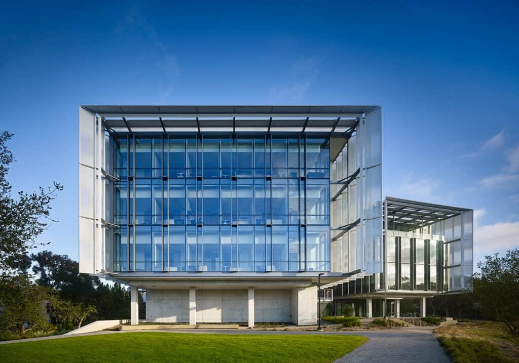 A modern building with a glass front set against a blue sky.