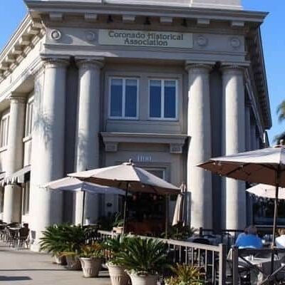 Front facade of historic building in Coronado, CA, featuring Roman style columns and architecture.